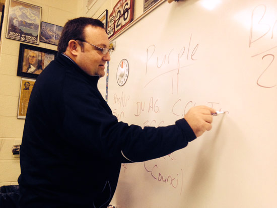 Andrew Hicks writes on a whiteboard at St. Thomas the Apostle school in Elkhart